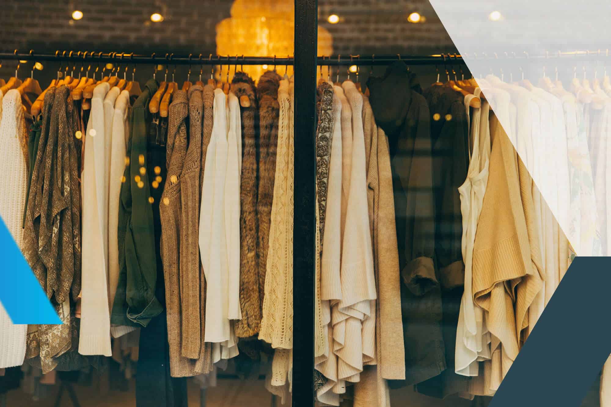 Un portant avec des habits dans une vitrine de magasin
